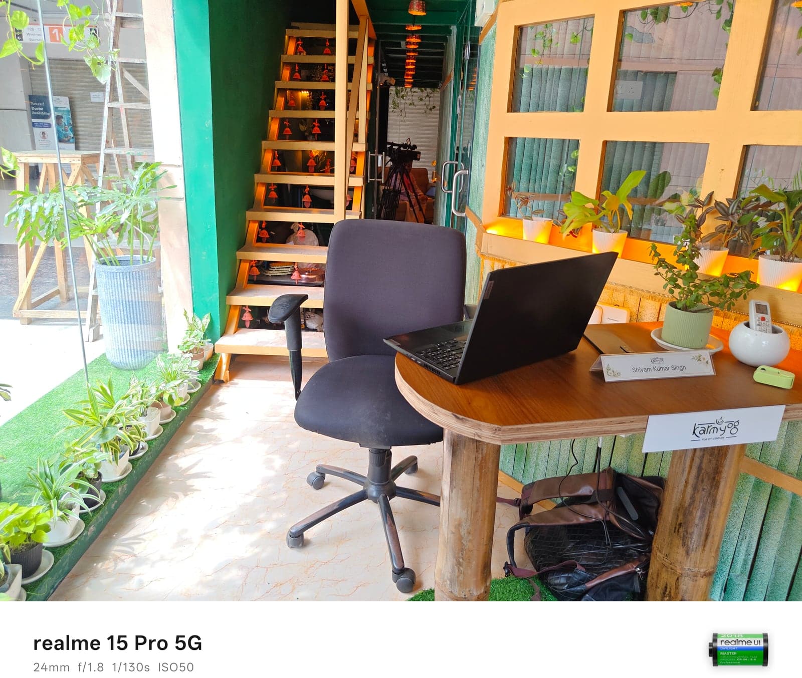 Grove meeting room with bamboo desk, greenery, and lit wooden staircase